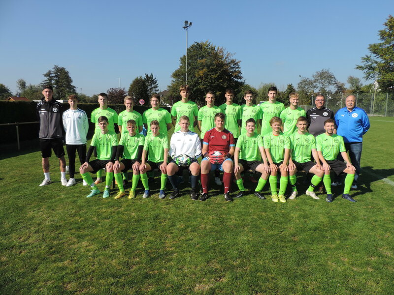 Eine Fußballmannschaft posiert für ein Gruppenfoto auf dem Spielfeld.