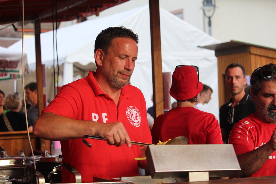 Ein Mann in rotem Hemd grillt im Freien und zaubert leckere Speisen