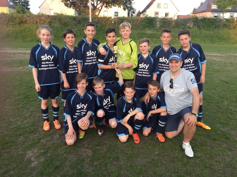Eine Gruppe von Jungen in Fußballtrikots posiert lächelnd für ein Foto.