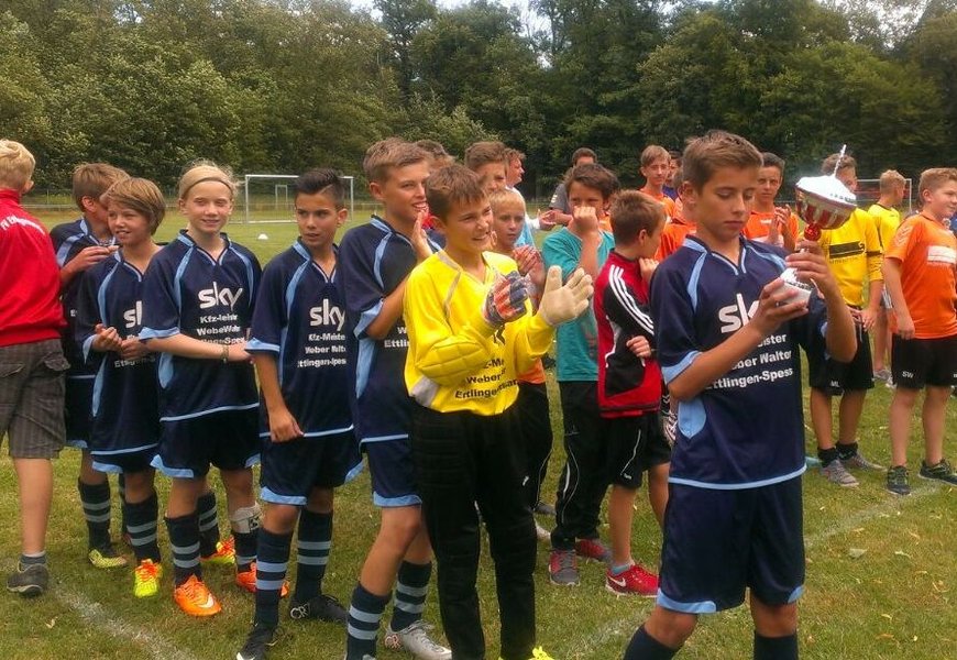 Mehrere junge Jungen versammeln sich um einen Fußball, bereit für ein spannendes Spiel.