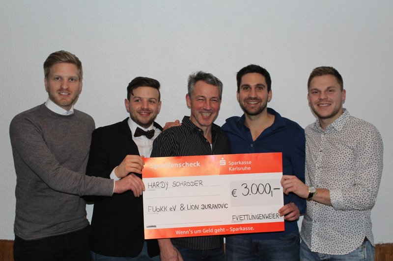 Eine Gruppe von fünf Männern hält einen großen Scheck über 3.000 Euro in der Hand, auf dem der Name „Hardy Schröder“ prangt.